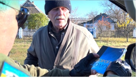 Image of the gospel being delivered from a vehicle to individuals in Ukraine.